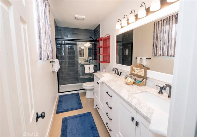 bathroom with tile patterned flooring, vanity, an enclosed shower, and toilet