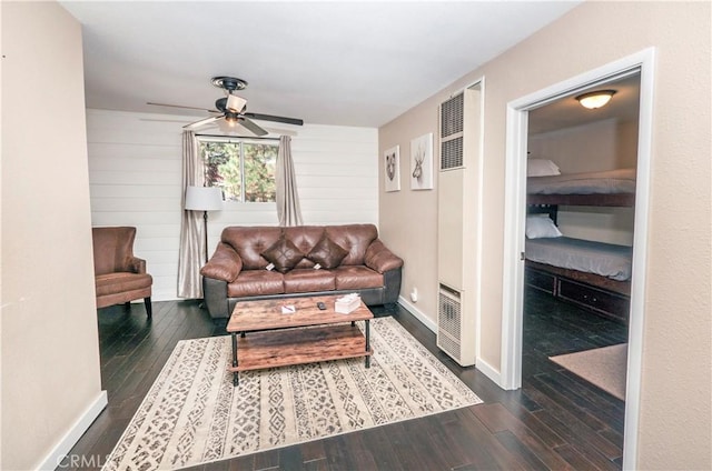 living room featuring wood walls, dark hardwood / wood-style floors, and ceiling fan