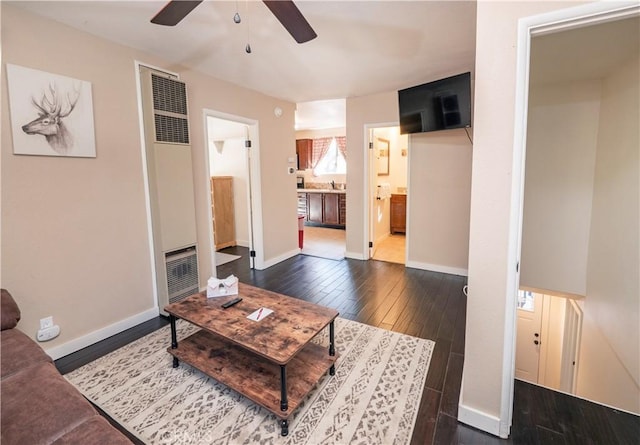 living room featuring ceiling fan and dark hardwood / wood-style flooring