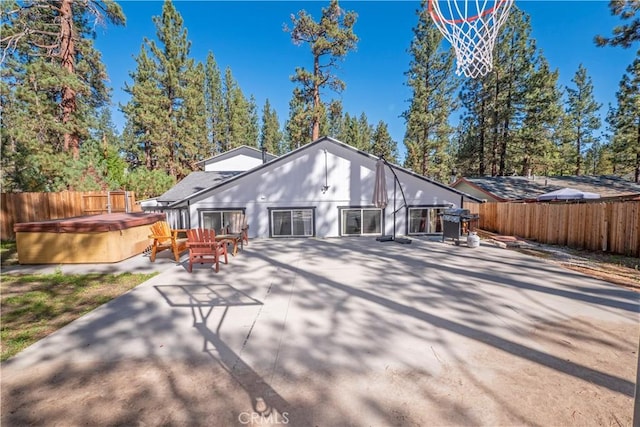 back of property with a patio area and a hot tub