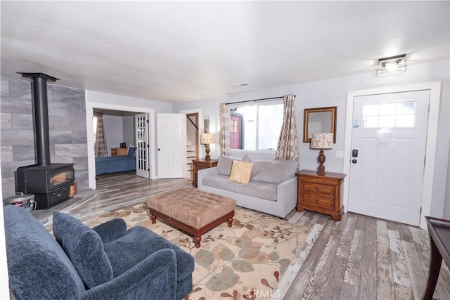 living room with hardwood / wood-style flooring, plenty of natural light, and a wood stove