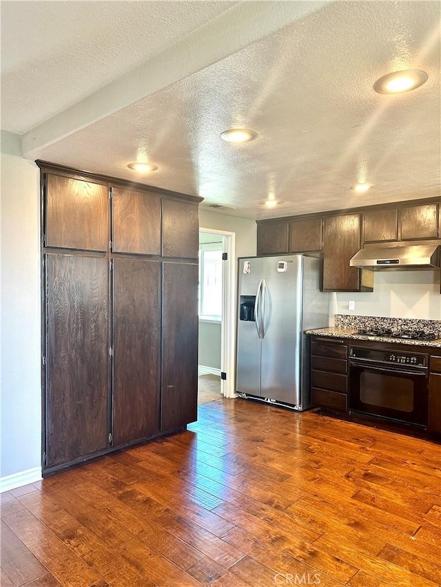 kitchen with a textured ceiling, dark hardwood / wood-style floors, black appliances, and dark brown cabinetry