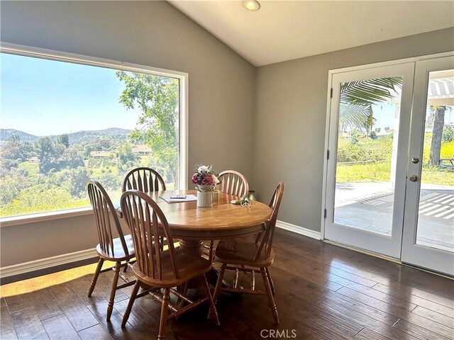 dining room featuring a mountain view, dark hardwood / wood-style floors, lofted ceiling, and french doors