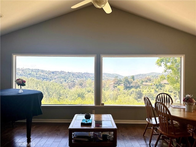 sunroom with ceiling fan, vaulted ceiling, and a mountain view