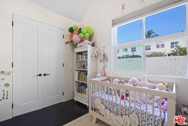 bedroom featuring a crib and vaulted ceiling