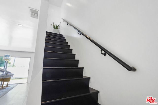 stairway with tile patterned floors