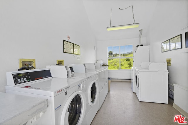 clothes washing area featuring light tile patterned flooring and washer and clothes dryer