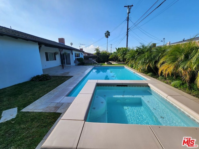 view of swimming pool with a lawn and an in ground hot tub