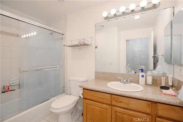 full bathroom with bath / shower combo with glass door, toilet, vanity, and tile patterned flooring