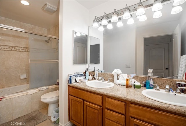 full bathroom featuring shower / bath combination with glass door, vanity, toilet, and tile patterned flooring