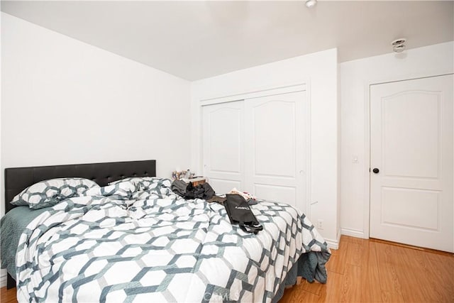 bedroom with a closet and light hardwood / wood-style floors