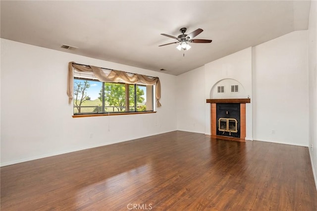 unfurnished living room featuring lofted ceiling, dark hardwood / wood-style flooring, a fireplace, and ceiling fan