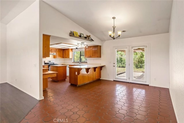 kitchen with a healthy amount of sunlight, pendant lighting, vaulted ceiling, and kitchen peninsula