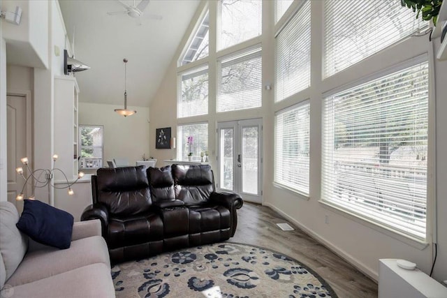 living room with ceiling fan, plenty of natural light, wood-type flooring, and french doors