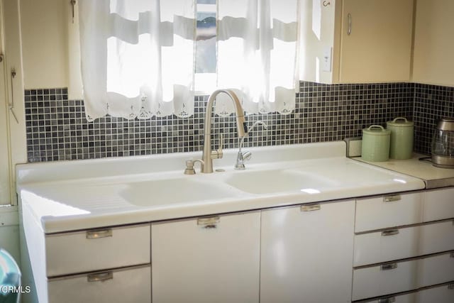 bathroom featuring vanity and tasteful backsplash