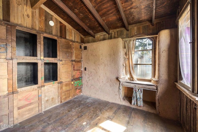 interior space with vaulted ceiling with beams, wooden walls, and hardwood / wood-style flooring