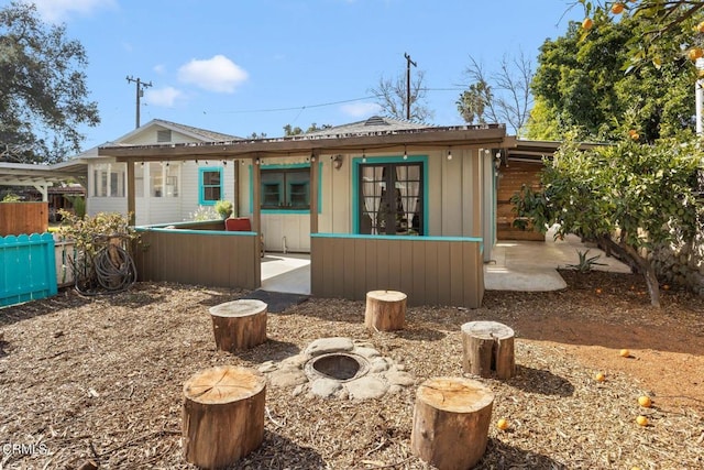 rear view of property featuring a fire pit and french doors