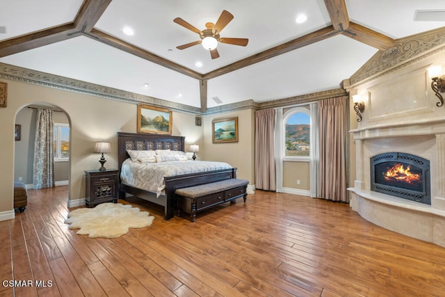 bedroom with ceiling fan, hardwood / wood-style floors, and beam ceiling