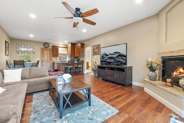 living room with hardwood / wood-style flooring, a fireplace, and ceiling fan