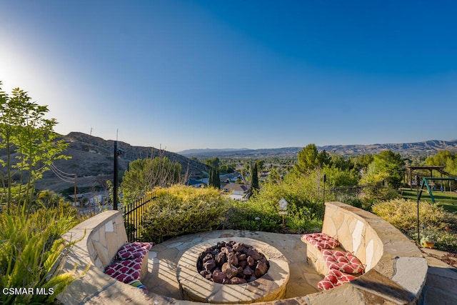 view of patio / terrace with a mountain view and an outdoor fire pit