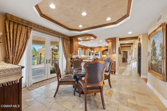 tiled dining area featuring crown molding, french doors, and a tray ceiling