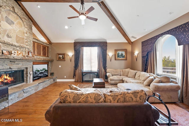 living room with beamed ceiling, a fireplace, a healthy amount of sunlight, and hardwood / wood-style floors