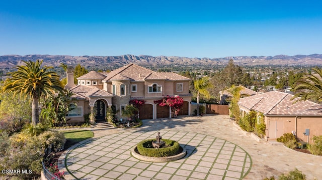 mediterranean / spanish house with a garage and a mountain view