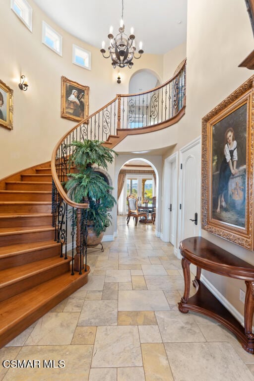 entrance foyer featuring tile patterned flooring, a high ceiling, and an inviting chandelier