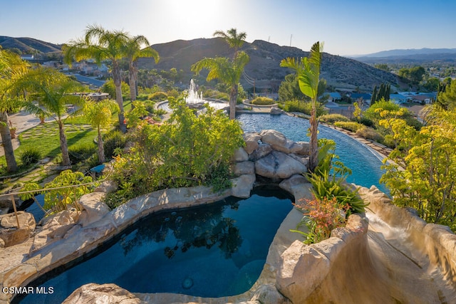 view of swimming pool with a mountain view