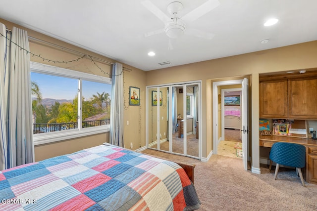 carpeted bedroom with ceiling fan and a closet