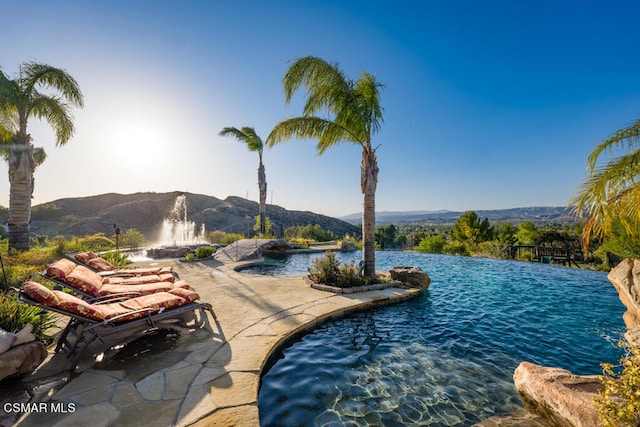 view of swimming pool with a mountain view