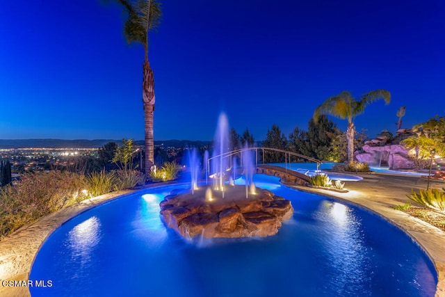 view of pool at twilight