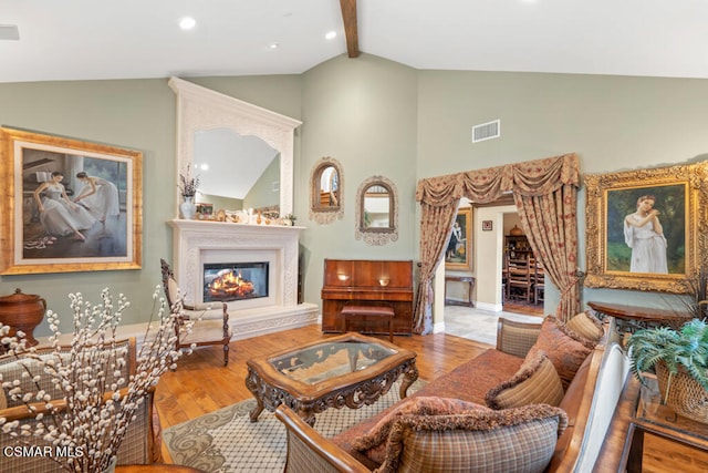 living room with high vaulted ceiling, hardwood / wood-style flooring, and beam ceiling