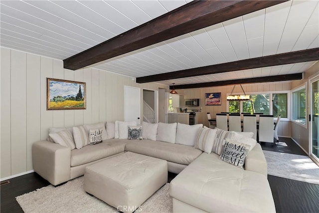 living room with beamed ceiling, hardwood / wood-style flooring, and wooden walls