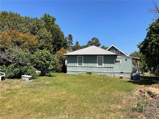 view of side of home with a yard