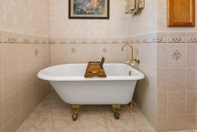 bathroom with a tub to relax in and tile walls