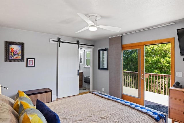 bedroom featuring connected bathroom, access to exterior, ceiling fan, and a barn door