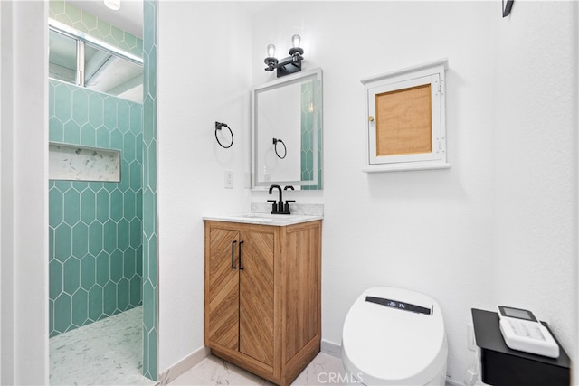 bathroom featuring tile patterned floors, vanity, a tile shower, and toilet