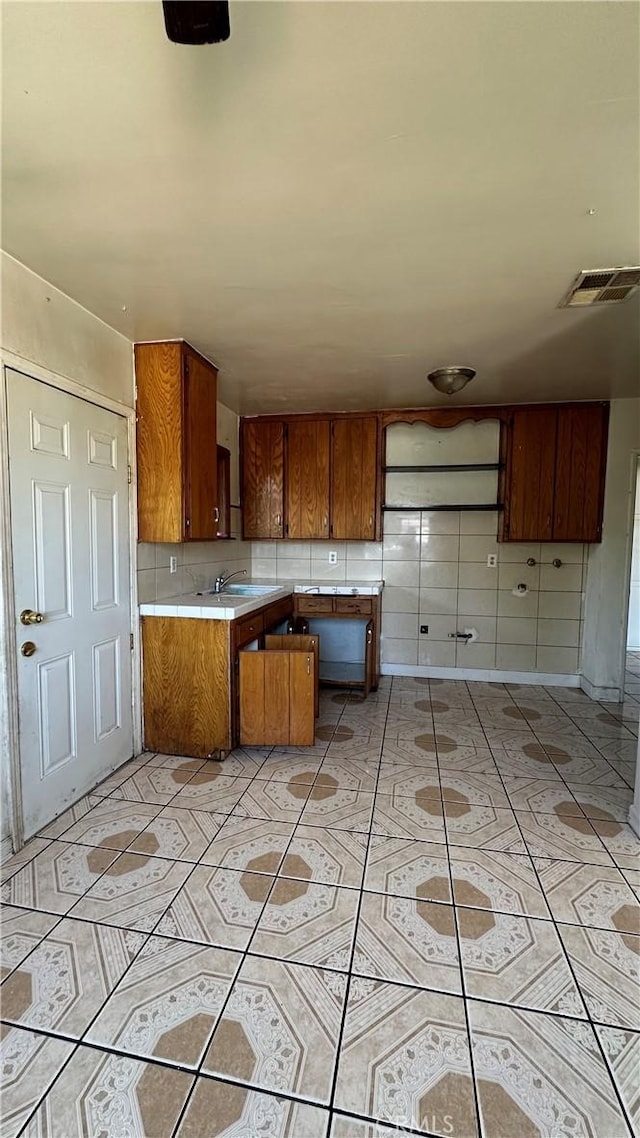 kitchen featuring light tile patterned floors, tasteful backsplash, and sink