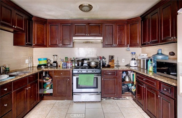 kitchen with light tile patterned flooring, appliances with stainless steel finishes, light stone counters, and sink