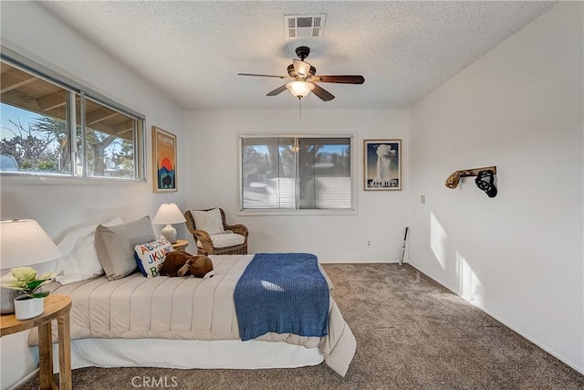 bedroom with a textured ceiling, carpet floors, and ceiling fan