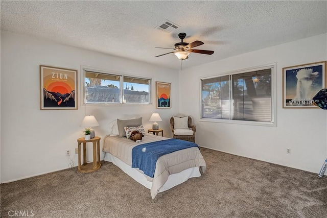 bedroom with carpet, a textured ceiling, and ceiling fan