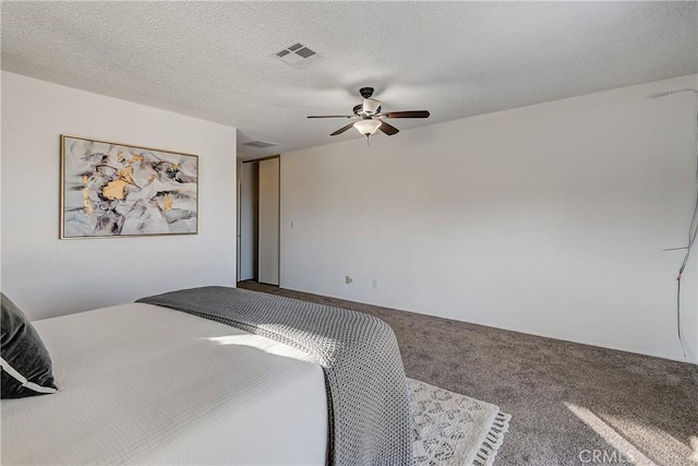 bedroom with a textured ceiling, carpet floors, and ceiling fan