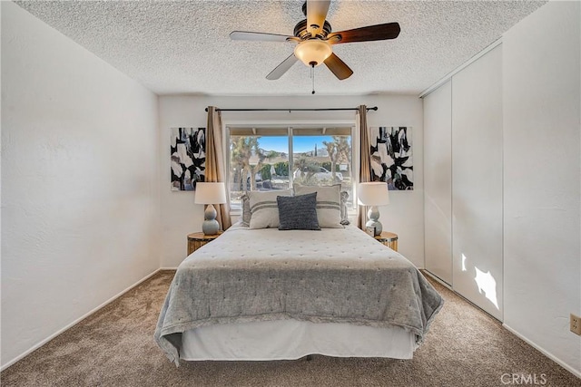 carpeted bedroom featuring ceiling fan and a textured ceiling