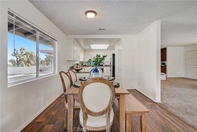 dining space featuring dark hardwood / wood-style floors and a textured ceiling