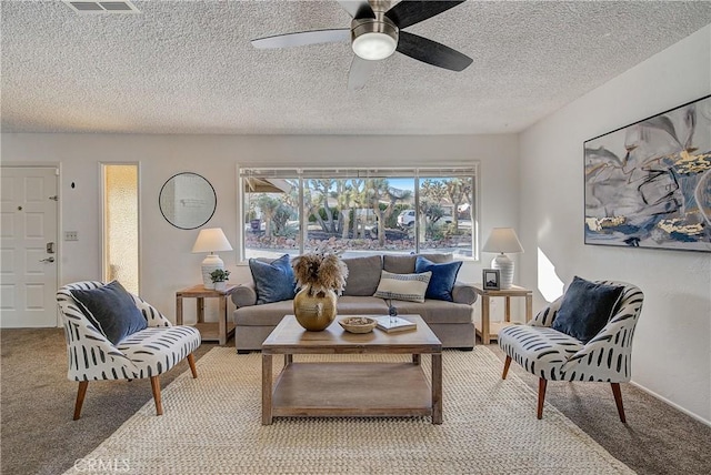 living room with carpet flooring, ceiling fan, and a textured ceiling