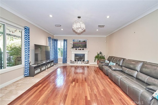 living room with crown molding, plenty of natural light, and light hardwood / wood-style floors