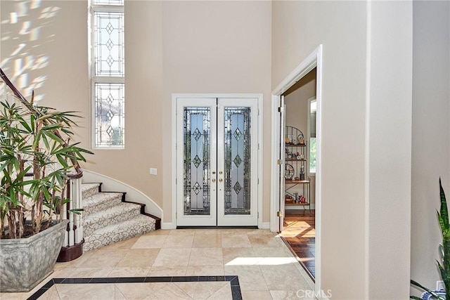 foyer entrance featuring a towering ceiling and french doors