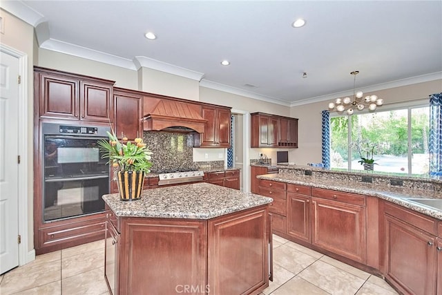 kitchen featuring a center island, hanging light fixtures, stainless steel range oven, black double oven, and custom exhaust hood