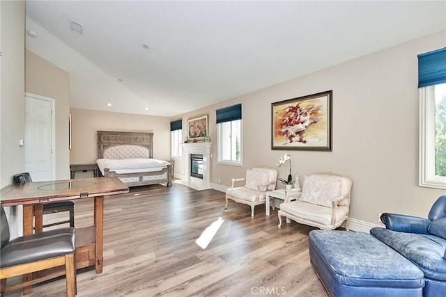 bedroom with light hardwood / wood-style flooring, multiple windows, and lofted ceiling